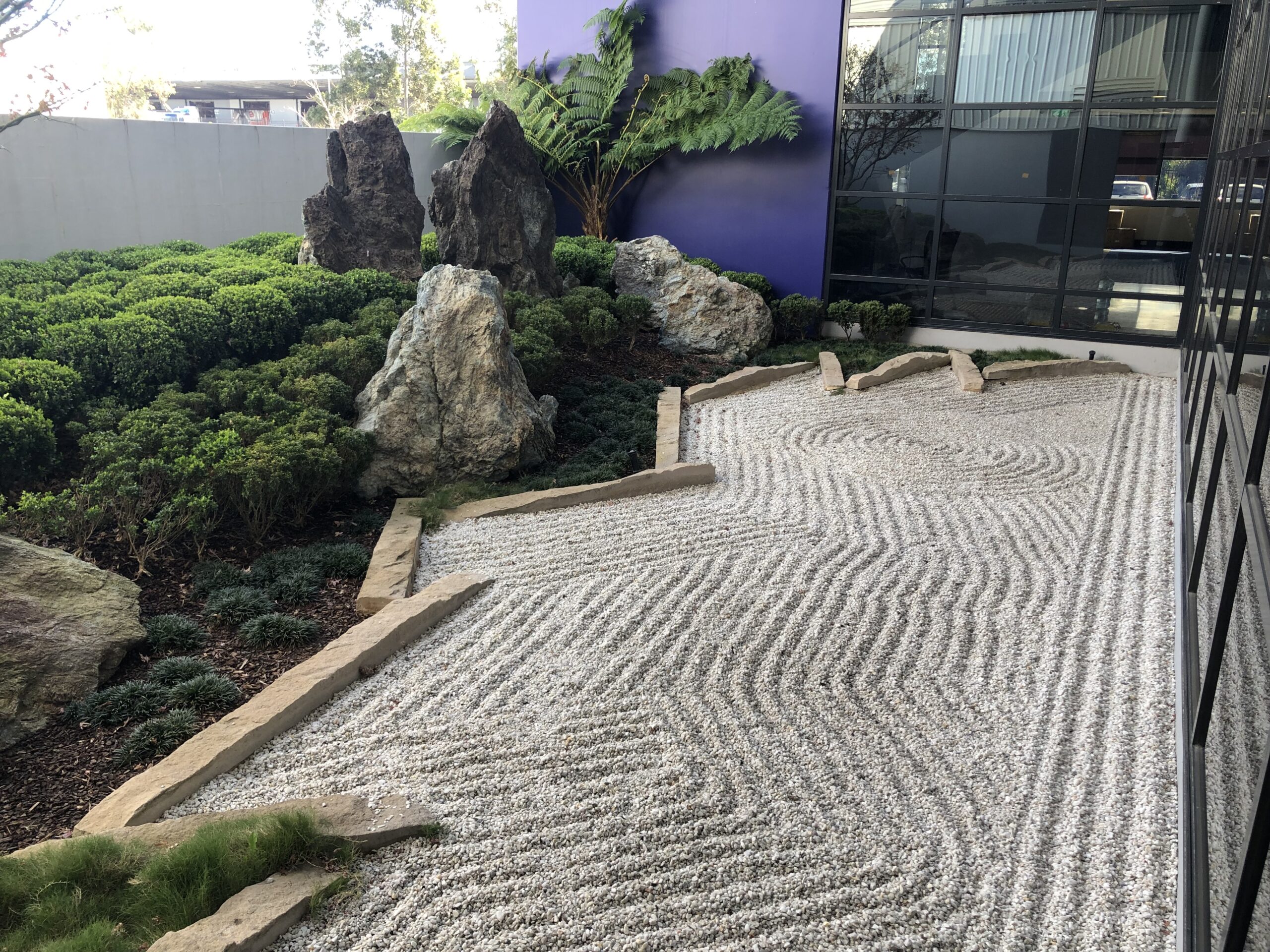 A beautiful Oriental garden in a commercial setting, with pebbles and feature rocks