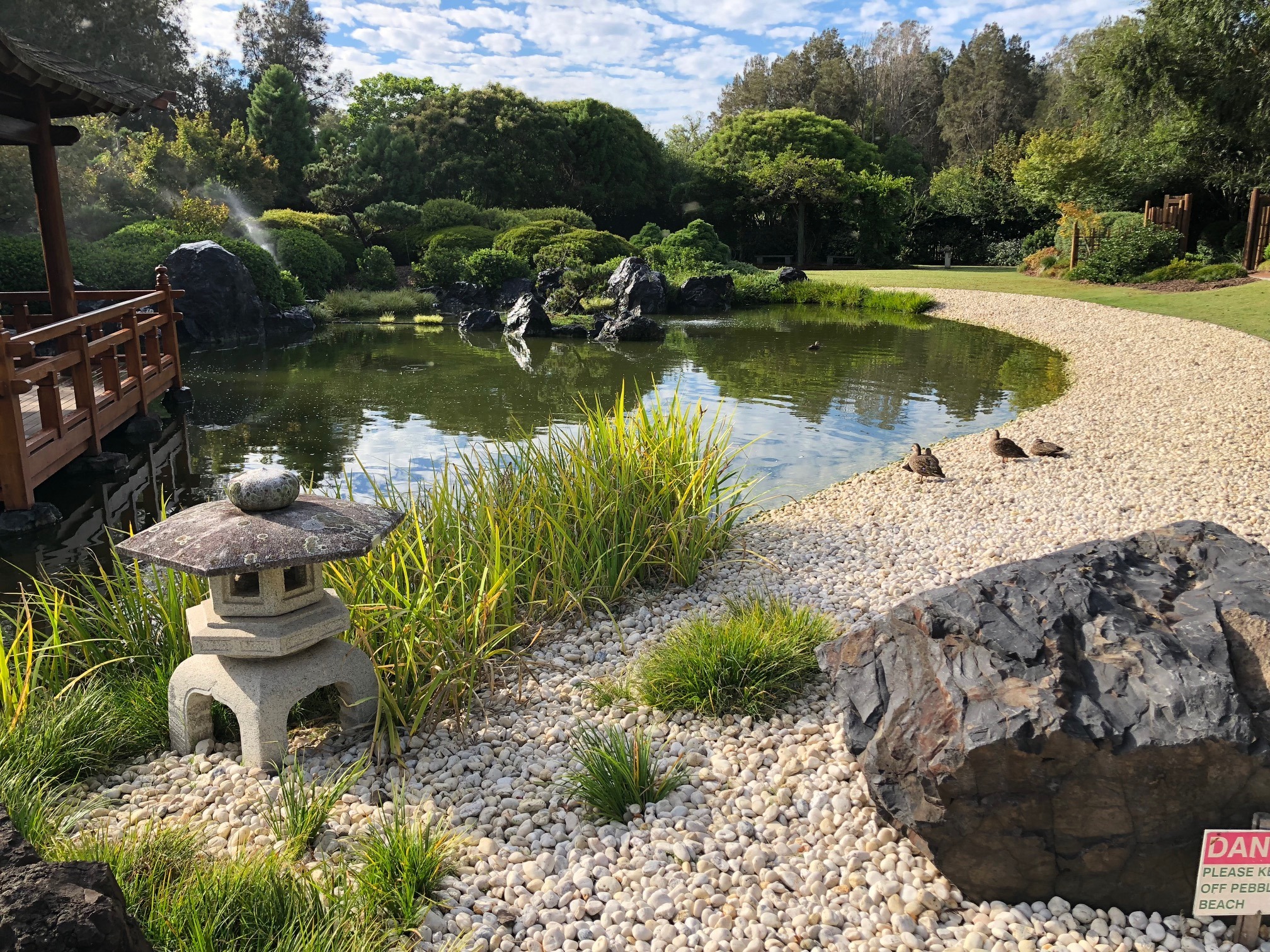 Japanese garden with large water feature and granite lantern