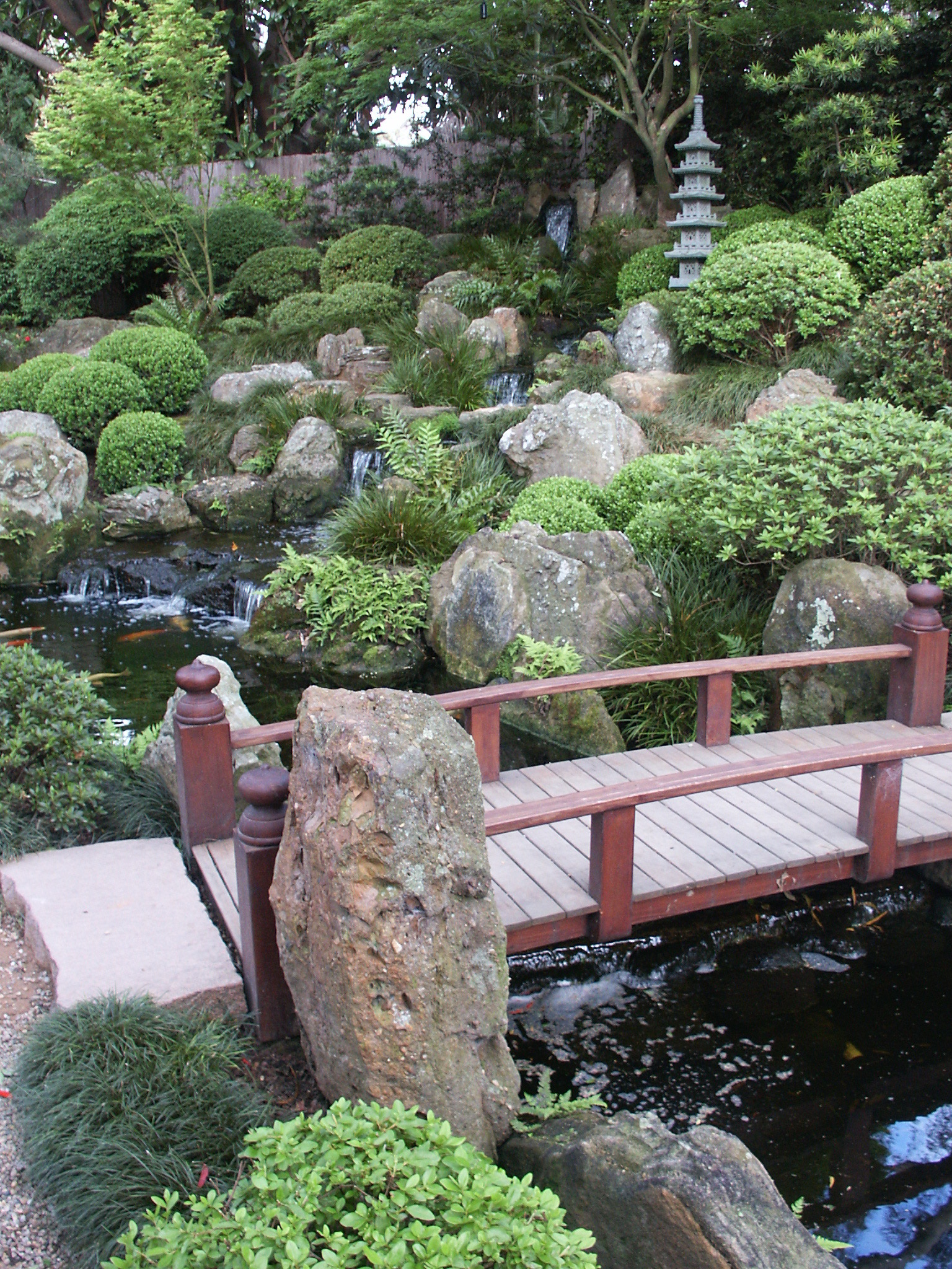 Commercial landscaping installation of foot bridge and water feature