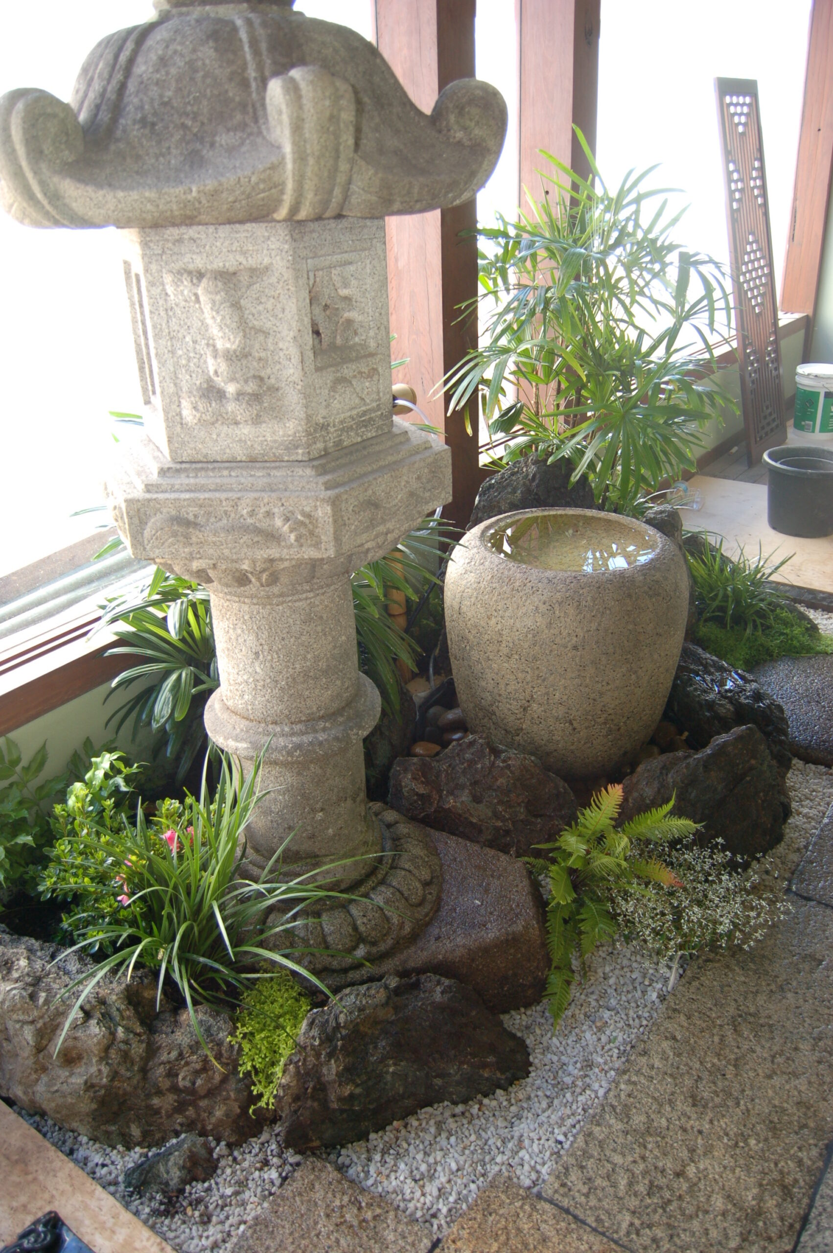 Interior feature garden with water bowl and granite lantern in a Japanese restaurant